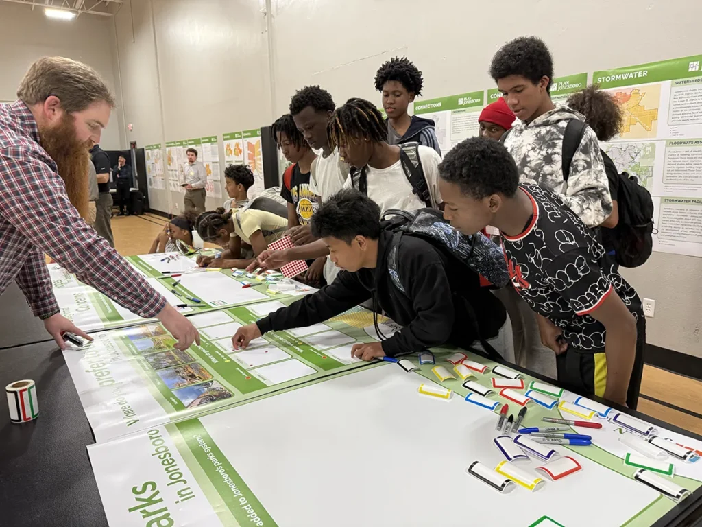 Official and students interacting with display
